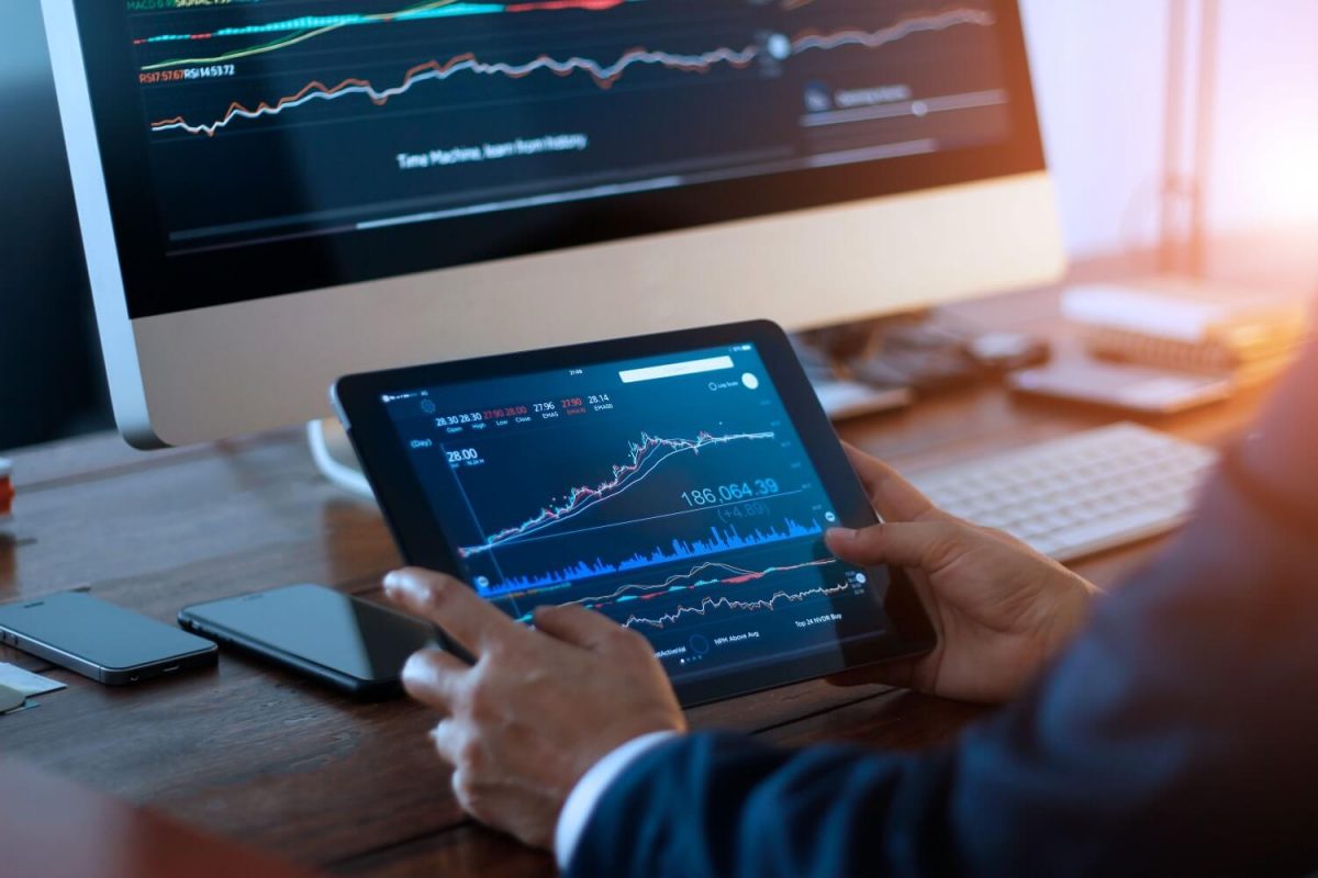 Investing in index funds - man viewing stock market graph on ipad